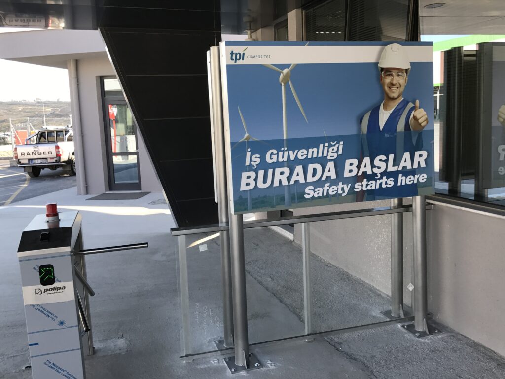 Fabrika girişinde çalışan ve ziyaretçileri bilgilendirmek için hazırlanan ayaklı iş güvenliği panosu