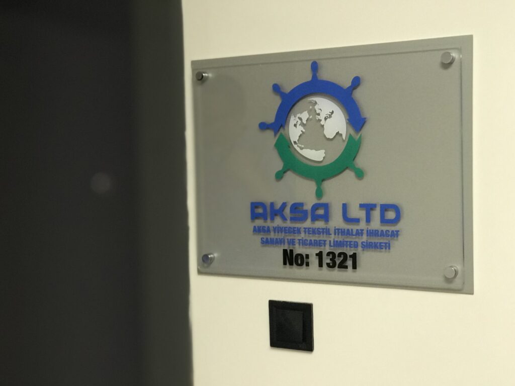 Ofis girişi için hazırlanan metal montaj aparatlı şeffaf pleksi şirket tabelası
