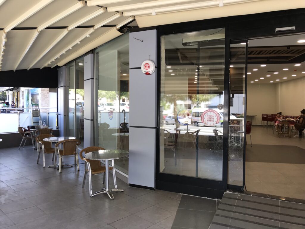 Restoran giriş cephesinde cam yüzey ve kompozit kolonlara uygulanan kurumsal reklam çalışması