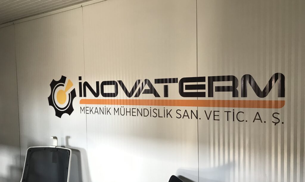 Fabrika iç mekân duvarına uygulanan özel kesim kurumsal logo ve folyo yazı çalışması